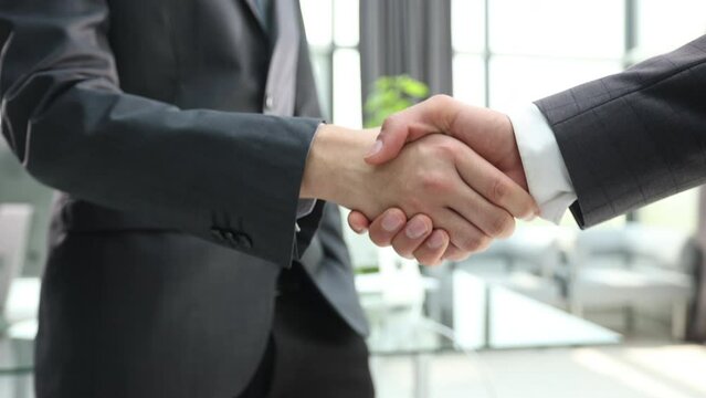 Building a strong business network. two businessmen shaking hands in a modern office