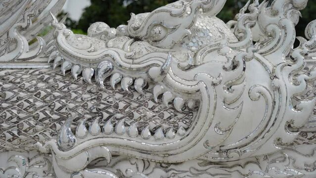 Detail of a dragon's mouth at Wat Rong Khun - White Temple in Chiang Rai, Thailand
