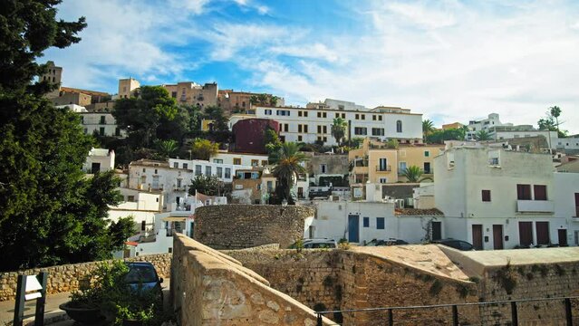 Beautiful view of Eivissa old town and its fortress with iconic tower clock. Old architecture and buildings of the Ibiza Town capital city on a sunny day with blue sky on the Balearic Islands, Spain