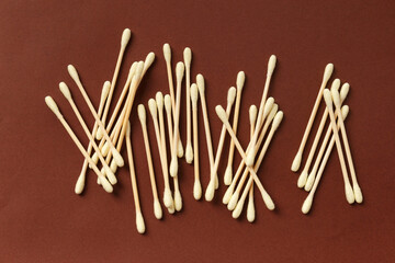 Cotton swabs buds sticks on a brown background.