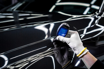 Measuring the thickness of a car paint coating with a thickness gauge