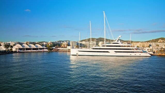 Luxury yachts and boats by Eivissa Harbour Port with buildings in background. Big yachts of millionaires and billionaires enjoying vacation on the Ibiza Island in Spain.