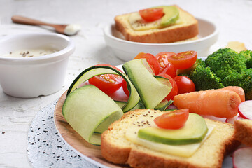 Close up of the Antioxidant vegetable salad served on a white plate with guacamole and cheese spread on toast accompanied by greek yogurt and chia seeds.