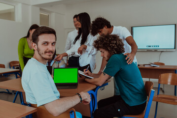 A group of business colleagues exchange knowledge and insights while utilizing laptops in the office, showcasing collaborative learning, effective communication, and a dynamic corporate environment