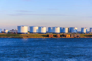 LNG storage tanks at coastal storage facility with blue ocean and sky - 641885894