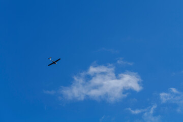 Small white cessna single propeller plane flying in a clear blue sky . High quality photo