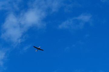 Fototapeta premium Small white cessna single propeller plane flying in a clear blue sky . High quality photo