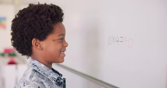 Math class, happy child at board for education, learning and problem solving for skill development. Boy writing on whiteboard in classroom with solution, thinking and smile at school for knowledge.