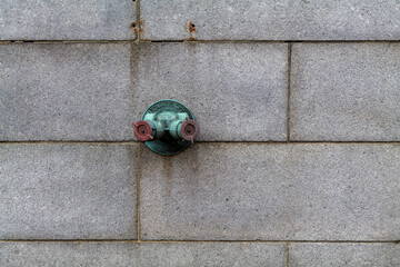 Fire hydrant water pipe, mounted in a building wall. Manhattan USA. High quality photo