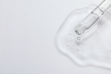 Dripping cosmetic oil from pipette onto light surface, closeup. Space for text