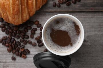 Coffee to go. Paper cup with tasty drink and beans on wooden table, flat lay