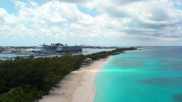 Paradise on ocean beach. Bahamas coast line. Drone footage, Blue water, White sand, Green palms, sunny weather. Summer day at the Caribbean's in Atlantic ocean. Blue clouds. Cruise ship, traveling. 