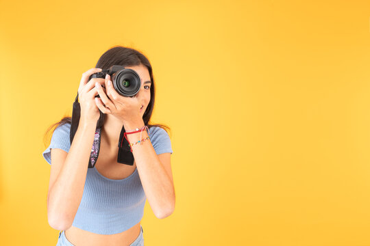 Hispanic young woman talking a photo with a digital camera
