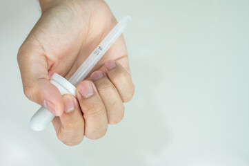 Someone hand holding a dropper. A dropper is use for measuring out drops of medicine or other liquids.