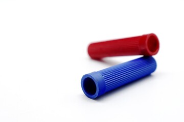 The two red and blue marker caps made of plastic appear photographed on the isolated white background