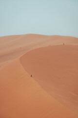 Fototapeta na wymiar People climbing Erg Chebbi dunes in Sahara Desert, Merzouga, Morocco