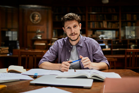 Portrait of a young caucasian male student studying in a university library