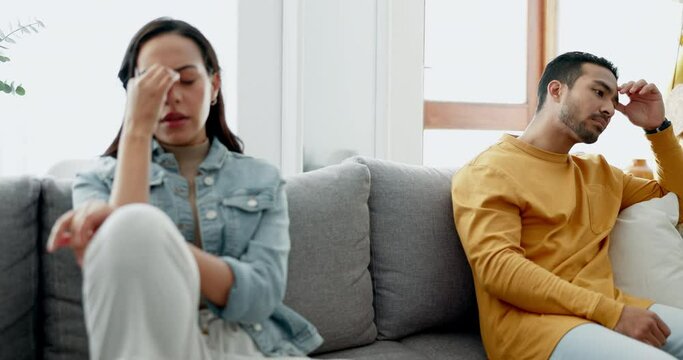 Sad, fight and couple angry on a couch together with drama, argument and toxic relationship in a home. Conflict, divorce and man has problem with sad woman in a living room sofa for cheating