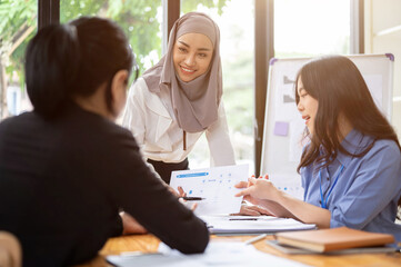 A confident Asian Muslim businesswoman is listening her teams ideas in the meeting.