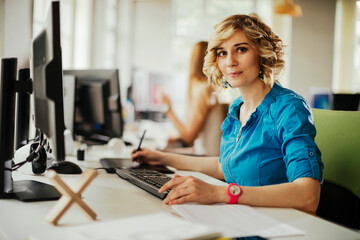 Young woman working a computer desk job