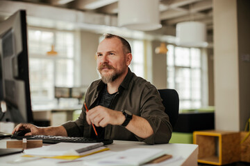Middle aged caucasian man using a computer at a office job