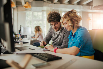 Young man and woman disscusing in a computer office