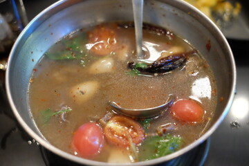 Fish boiled in spicy soup with  homemade cooking vegetable soup in a pot.