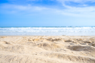 Beach sand background for summer vacation concept. Beach nature and summer seawater with sunlight light sandy beach Sparkling sea water contrast with the blue sky.