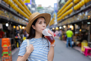 Travel woman drink of iced tea at Keelung street market