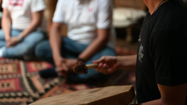 Persona tocando un tambor peque&ntilde;o en meditaci&oacute;n