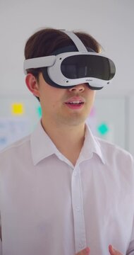 Businessman wearing VR and work in office. He using VR to talking with team in online meeting at Metaverse world. Innovation, Technology, Lifestyle, Business, Communication, Digital and Data concept.