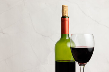Chilean wine, national day. Close-up, bottle of red wine, on wooden table, glass, cork. With space to copy