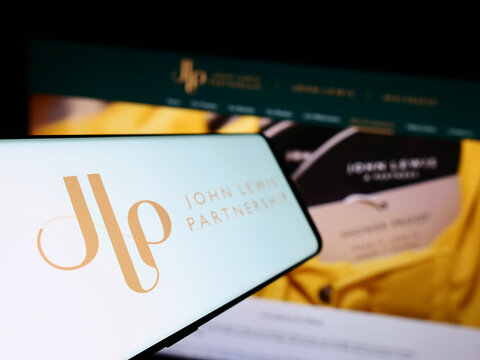Stuttgart, Germany - 08-29-2023: Cellphone with logo of retail company John Lewis Partnership plc on screen in front of business website. Focus on left of phone display.