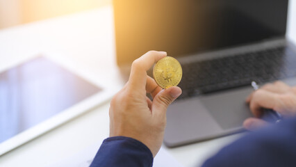 Businessman hand holds gold Bitcoin logo symbol Crypto using computer laptop for trading, money investment on Bitcoin Cryptocurrency. Trading Bitcoin Crypto on mobile app or online internet platform. - 641953234