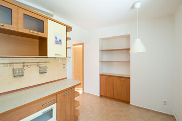 the interior of a non-modern kitchen in an older apartment with white walls.