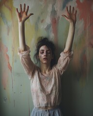 Fototapeta na wymiar Girl raised her hands in front of her face, the woman is scared and anxious, pastel color background