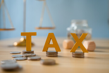 income tax wooden letters tax concept Data analysis, documents, financial research, reports, tax return calculations.