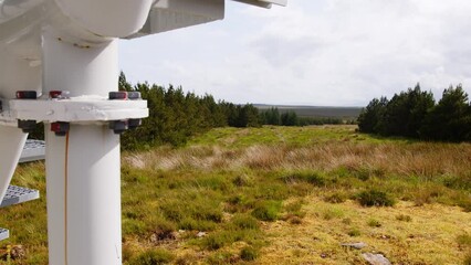Shot of nuts and bolts beside a wind turbine with moor and peatland.