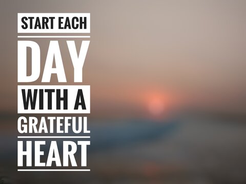 Motivational quote "Start each day with a grateful heart" on blurred nature background.