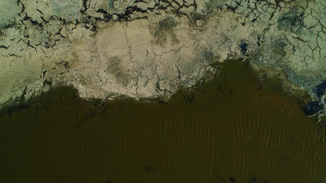 Drone rising top down view of toxic green water lining asphalt lake runoff, willemstad