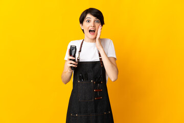 Hairdresser woman isolated on yellow background with surprise and shocked facial expression