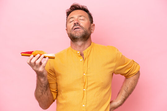 Middle Age Caucasian Man Holding Sashimi Isolated On Pink Background Suffering From Backache For Having Made An Effort