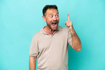Fototapeta premium Middle age caucasian man isolated on blue background intending to realizes the solution while lifting a finger up