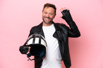 Middle age caucasian man with a motorcycle helmet isolated on pink background counting five with fingers