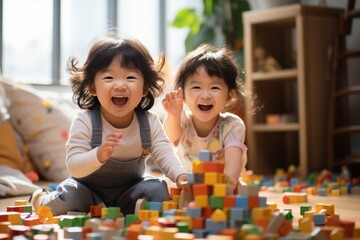 Happy two asian children playing with blocks. Cute little children playing while sitting at home - Powered by Adobe