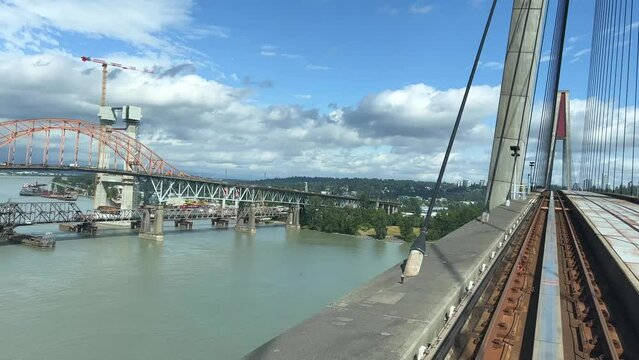 PATTULLO BRIDGE back window train on the bridge another blue train passes light traffic in big cities vancouver ordinary people work road comfort tourists canada vancouver 2023