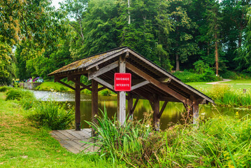 Swimming prohibited. Pontoon at the edge of the canal with a sign mentioning forbidden swimming written in French.