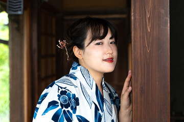 縁側でポーズをとる浴衣の女性