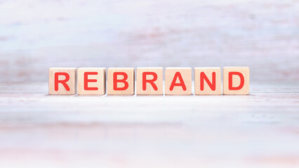 REBRAND word made of wooden cubes on a light background