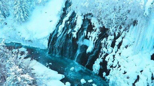 Shirahige Waterfall with Snow in winter, Biei river flow into Blue Pond. landmark and popular for attractions in Hokkaido, Japan. Travel and Vacation concept